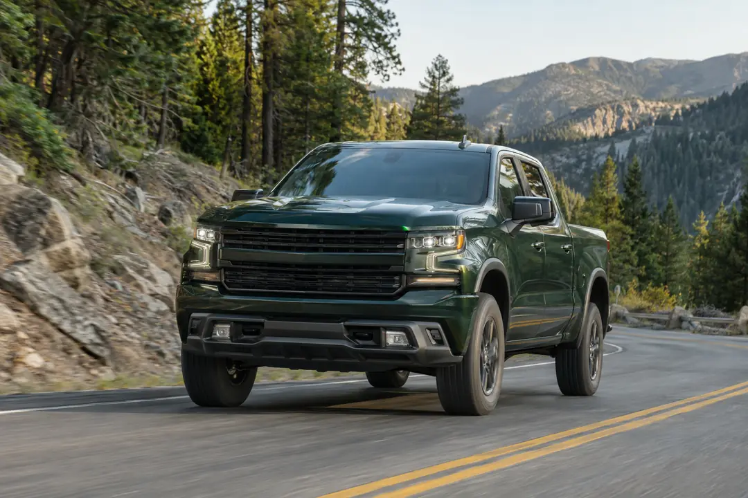 A pickup on a mountain road among pines