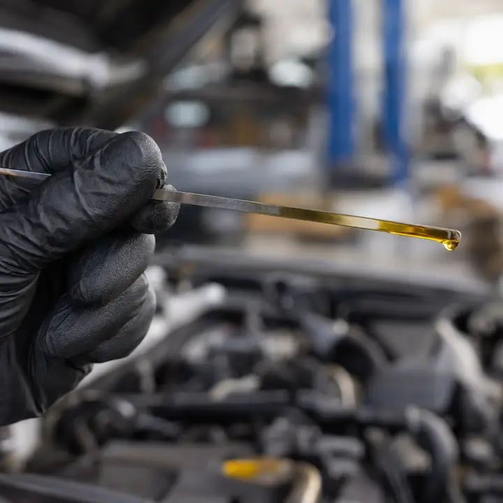 A dipstick with a drop of clean oil at its tip